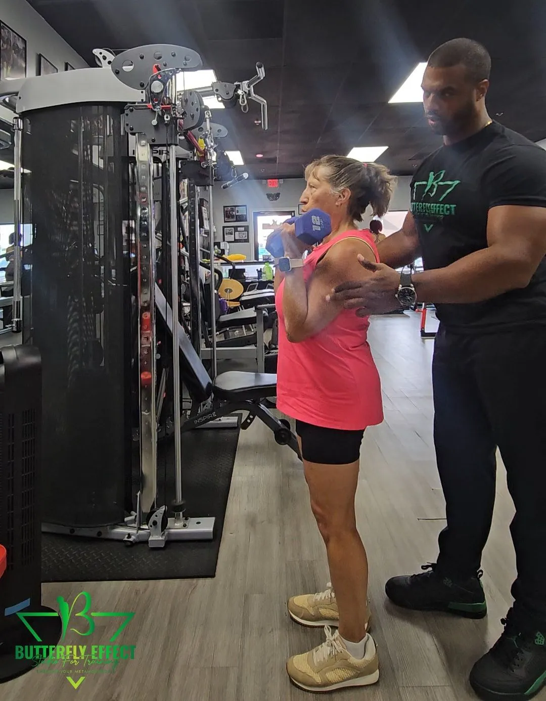 Coach supporting a member through a strength exercise
