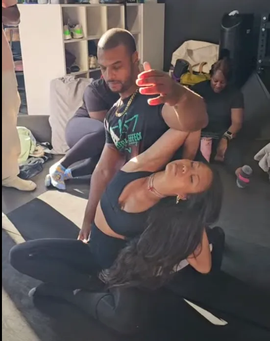Coach guiding a member through a floor mobility exercise