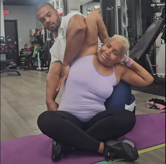 Coach assisting a member with a seated stretch