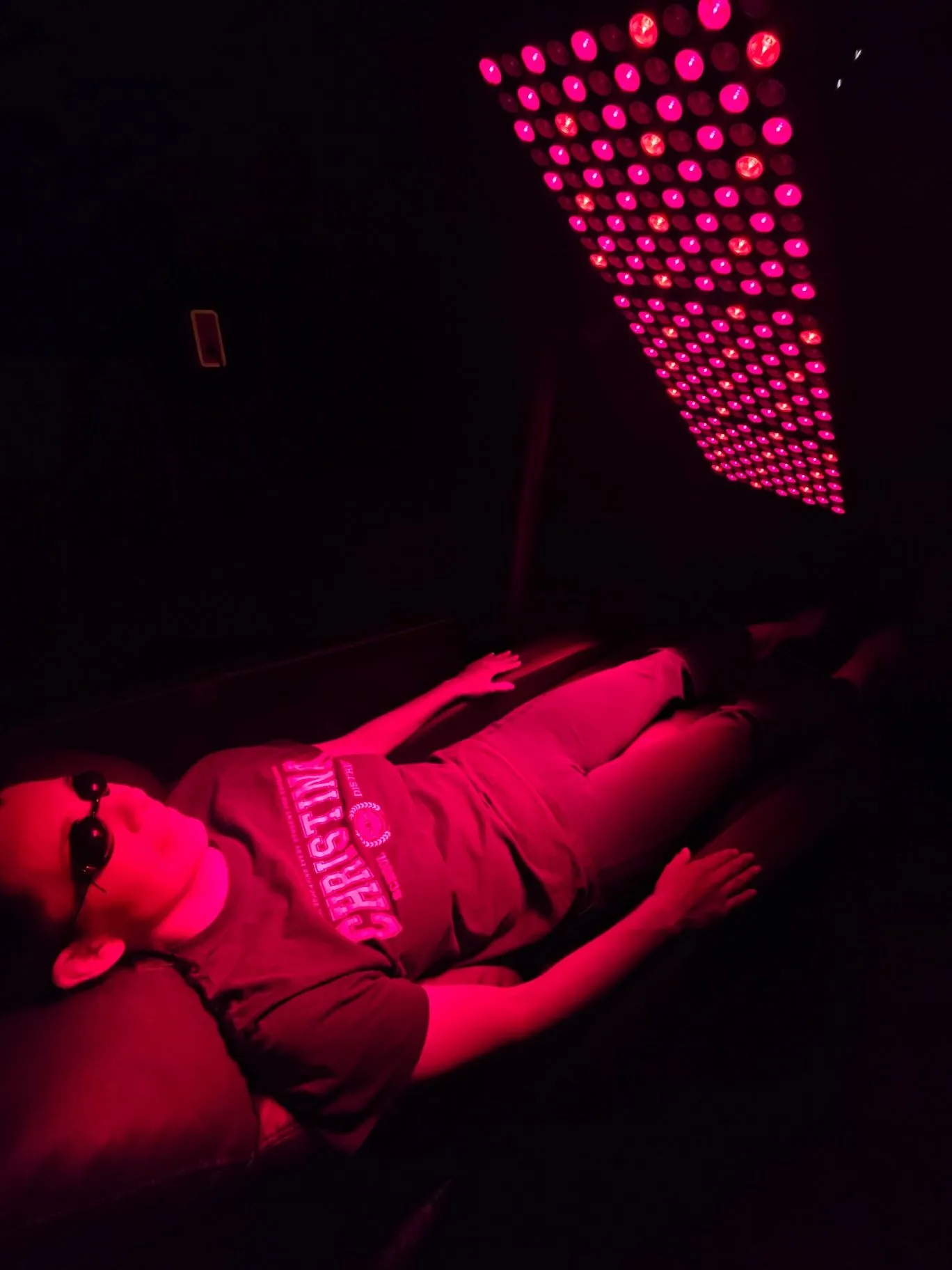 Person using a red-light therapy panel
